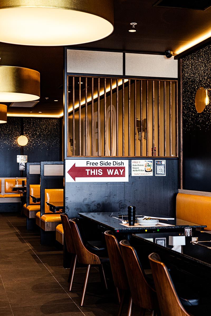 Restaurant Interior With Warm Lighting, Yellow Seating, and a Sign — JMB Electrical Services In Port Kembla, NSW