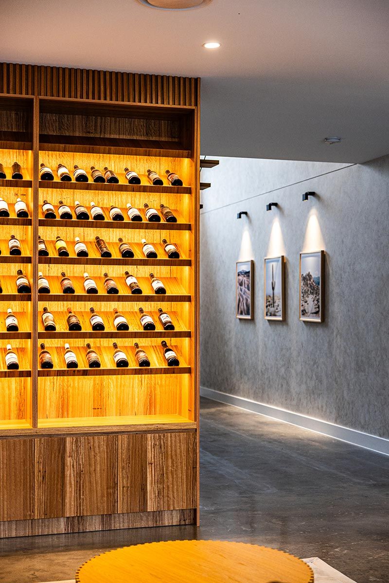 Wine Display With Bottles on Wooden Shelves — JMB Electrical Services In Port Kembla, NSW