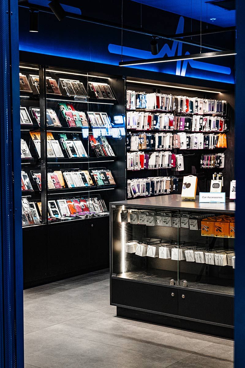 A Store Displays Phone Cases and Accessories on Dark Shelves — JMB Electrical Services In Port Kembla, NSW
