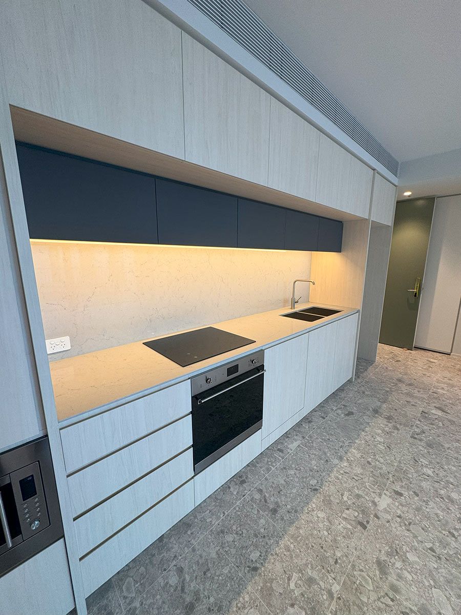 Modern Kitchen With Light Wood Cabinets and a Marble Countertop — JMB Electrical Services In Port Kembla, NSW