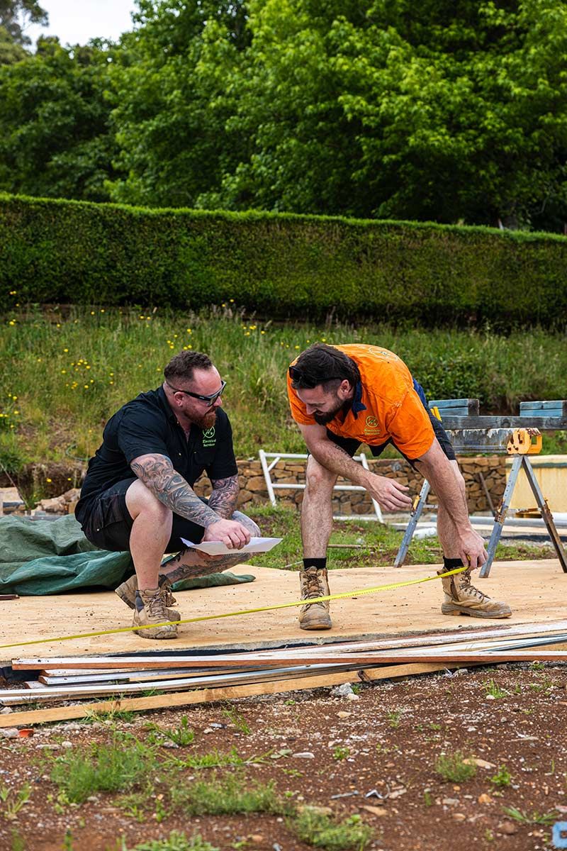 Two Men Work Outdoors on a Construction Project — JMB Electrical Services In Port Kembla, NSW