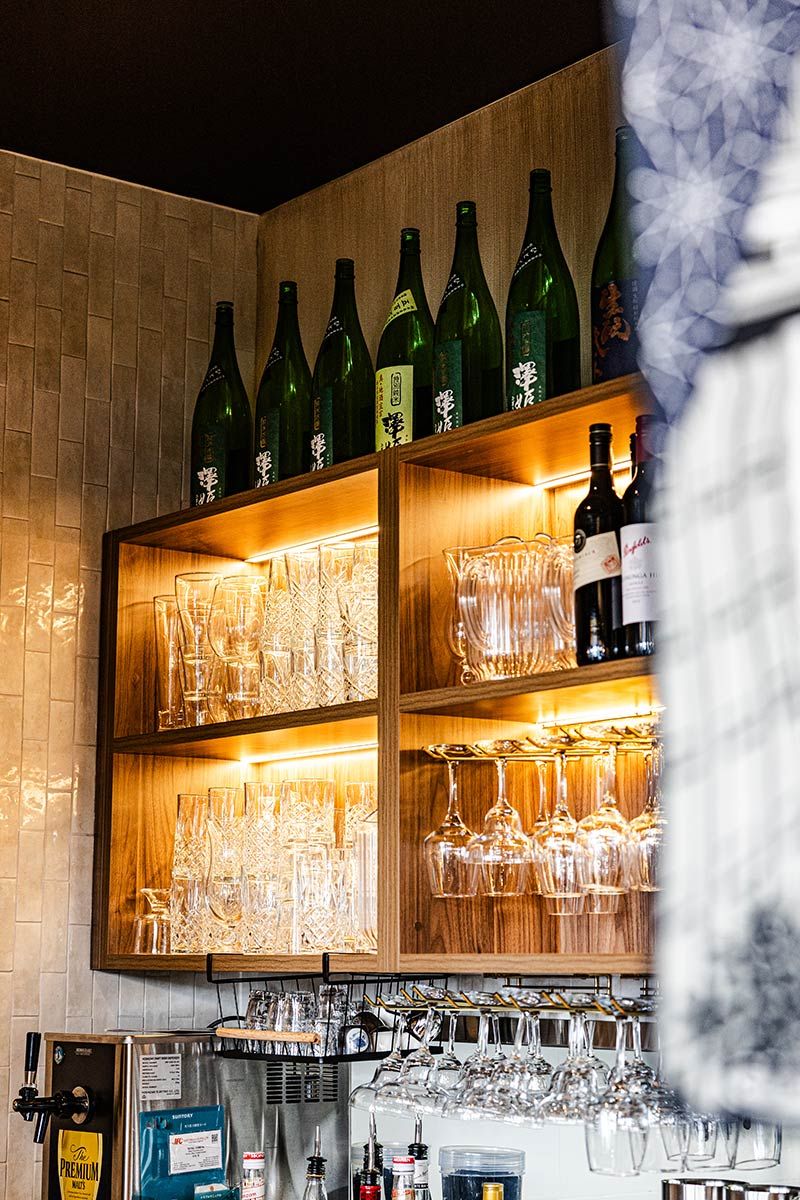 Wooden Shelves With Glassware and Bottles — JMB Electrical Services In Port Kembla, NSW
