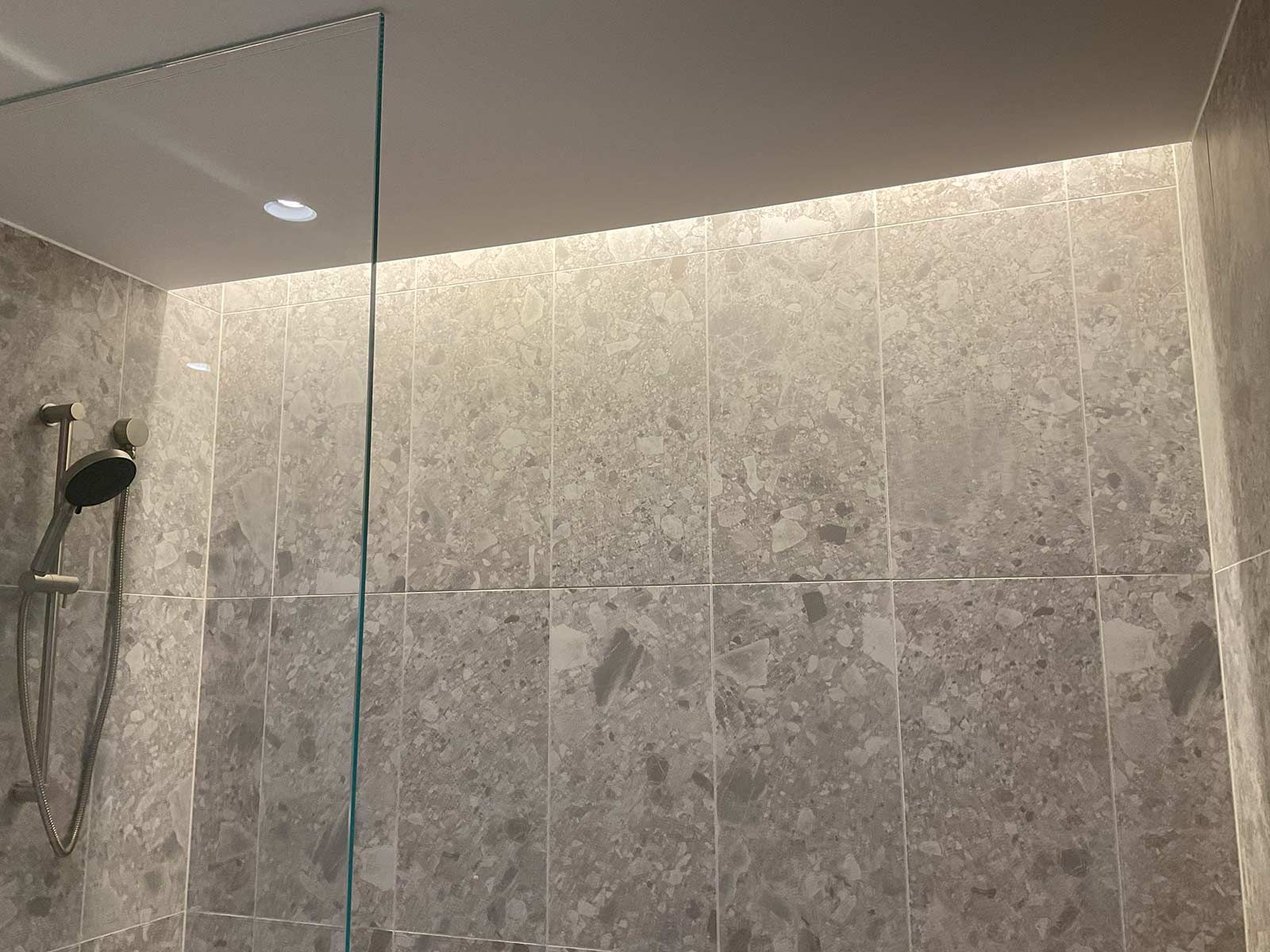 Modern Shower With Gray Stone Tiles and a Glass Partition — JMB Electrical Services In Port Kembla, NSW