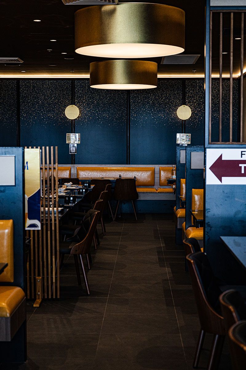 Restaurant Interior With Wooden Chairs and Large Overhead Lights — JMB Electrical Services In Port Kembla, NSW