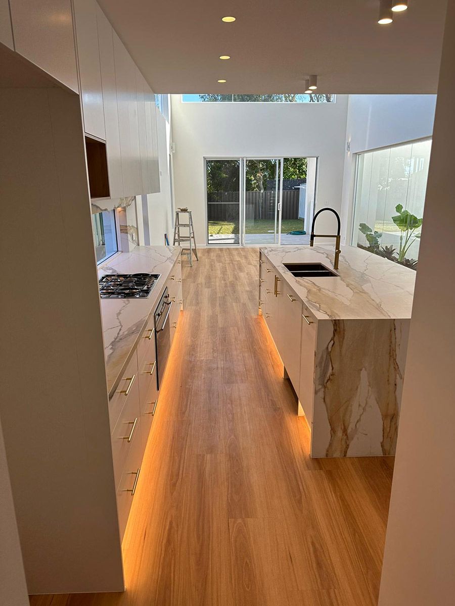 Kitchen With Wood Floors and Marble Countertops — JMB Electrical Services In Port Kembla, NSW