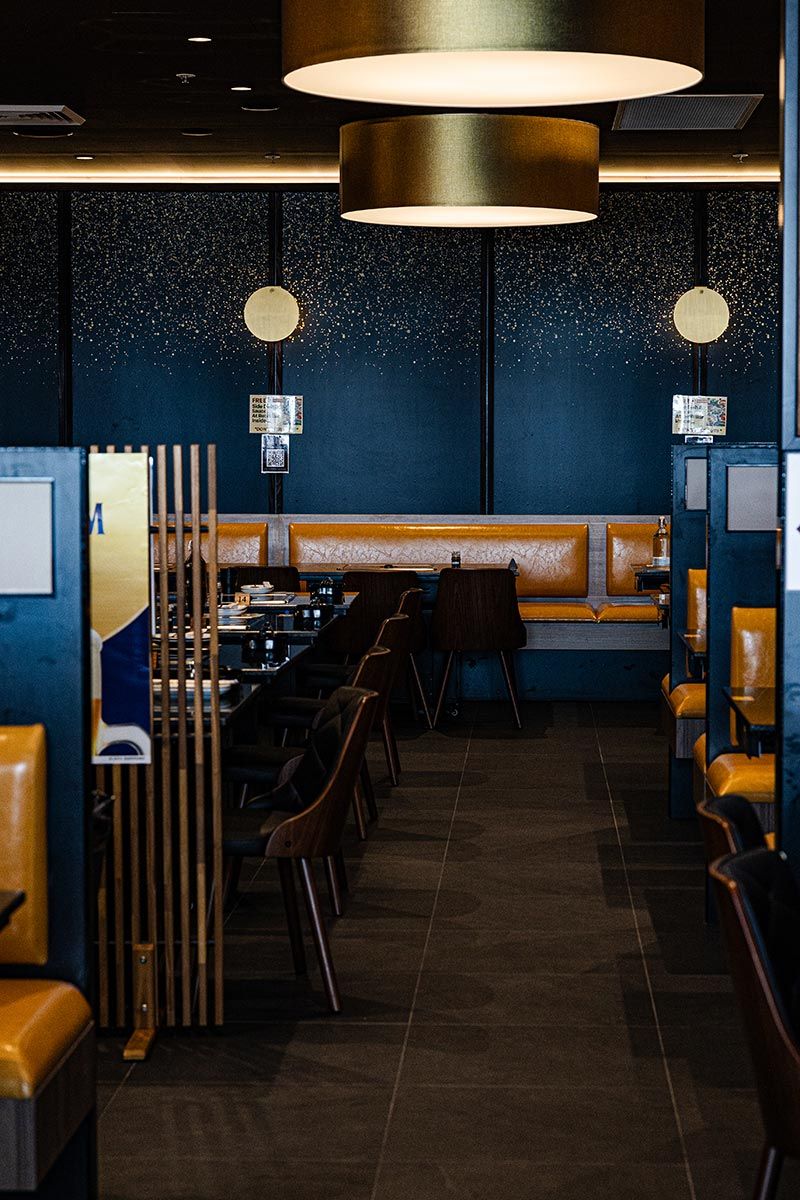 Restaurant Interior With Amber Leather Seating, Dark Wood Tables, and Chairs — JMB Electrical Services In Port Kembla, NSW