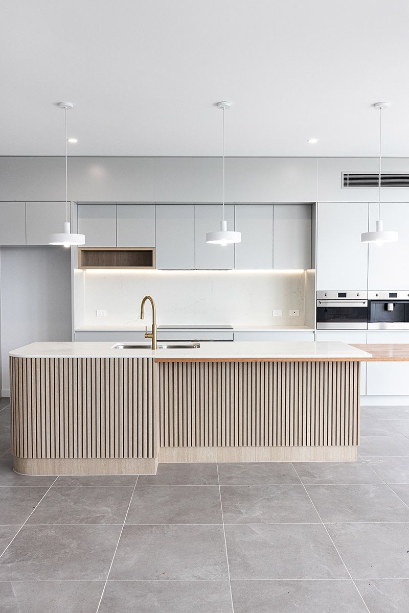 Modern Kitchen Features a Textured Island With a Gold Faucet — JMB Electrical Services In Port Kembla, NSW