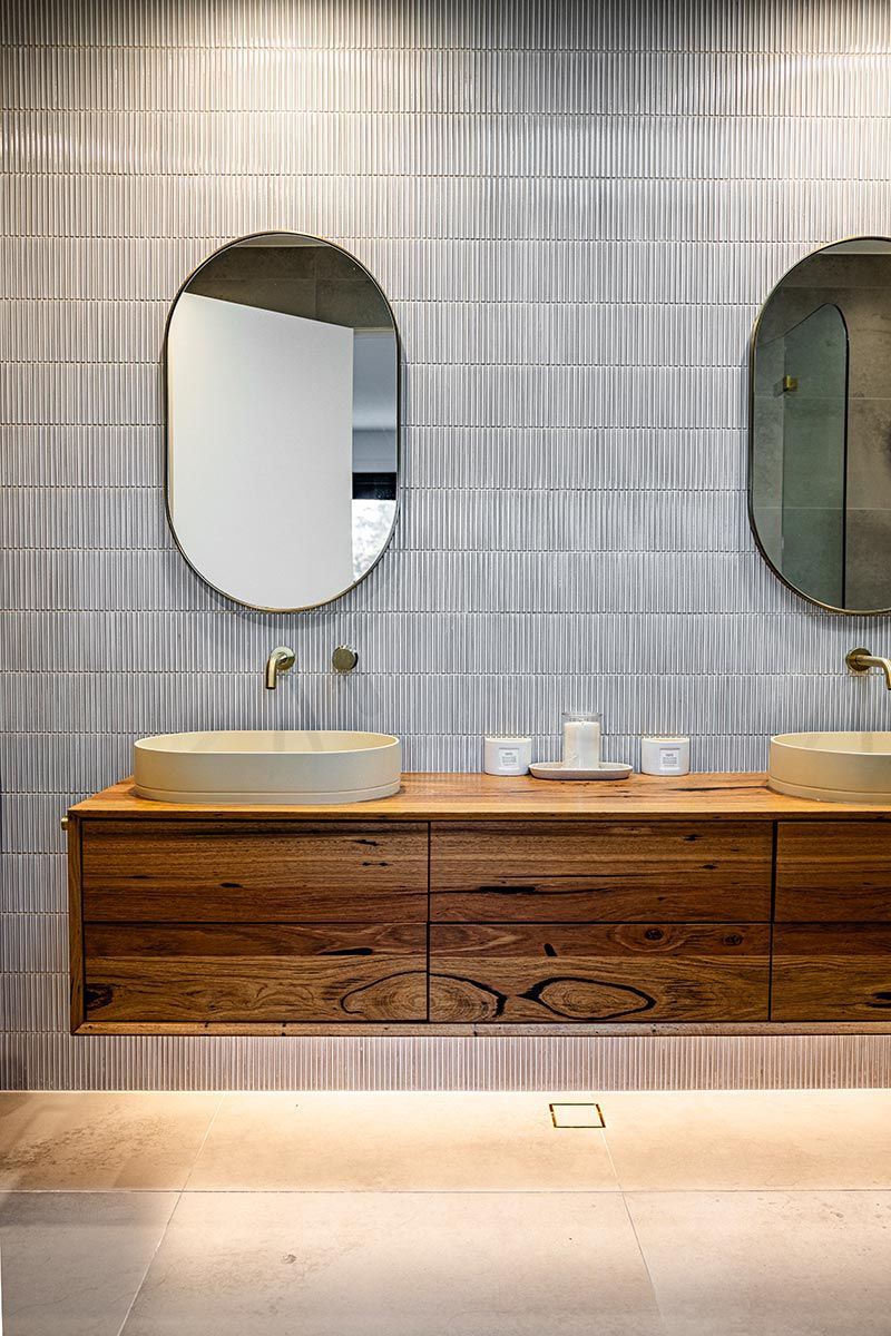 Bathroom With Two Oval Mirrors Above a Wooden Vanity — JMB Electrical Services In Port Kembla, NSW