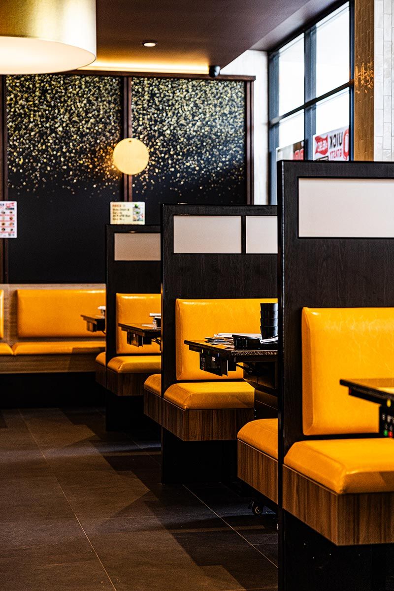 Modern Restaurant With Yellow Booth Seating and Black Dividers — JMB Electrical Services In Port Kembla, NSW