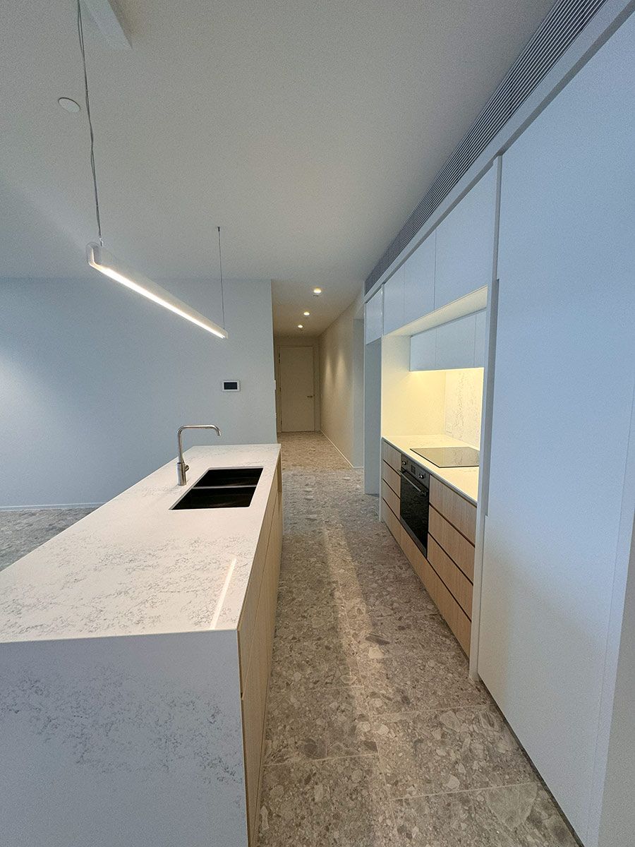 Modern Kitchen Features a Marble Island With Sink — JMB Electrical Services In Port Kembla, NSW