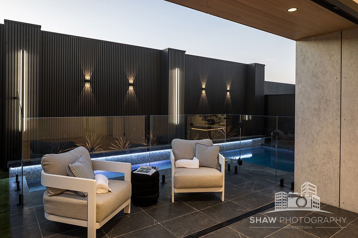Two Chairs Are Sitting on a Patio Next to a Pool — JMB Electrical Services In Port Kembla, NSW