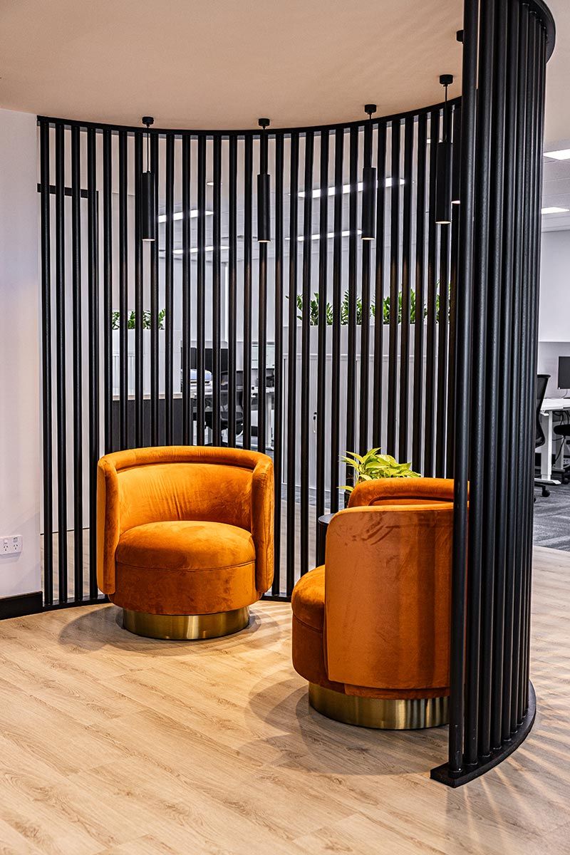 Two Orange Velvet Chairs Sit in a Modern Office Space — JMB Electrical Services In Port Kembla, NSW
