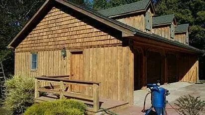 A large wooden house with a blue vacuum cleaner in front of it.