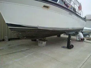 A boat is sitting on top of a concrete surface next to a building.