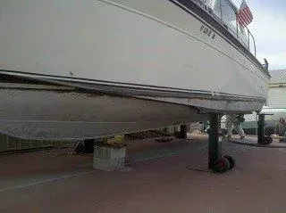A boat is sitting on top of a concrete block on wheels.