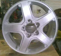 A silver wheel is sitting on top of a wooden table.
