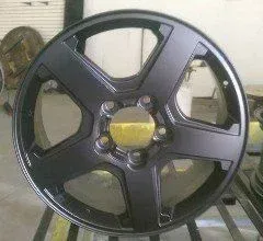 A black wheel is sitting on top of a metal table.