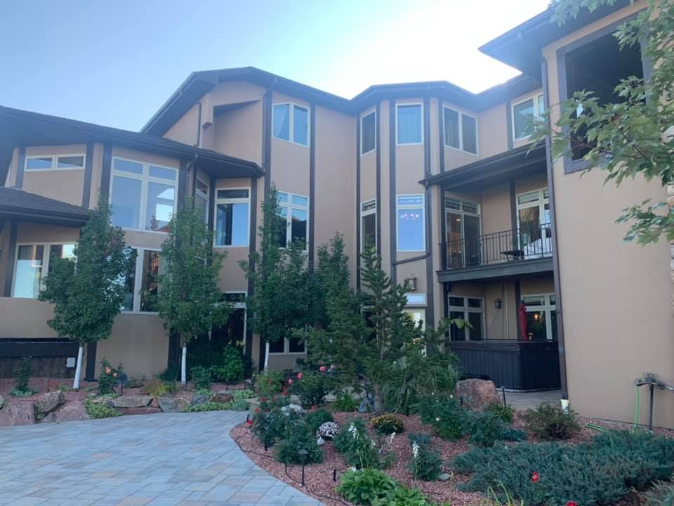 A large house with lots of windows and trees in front of it