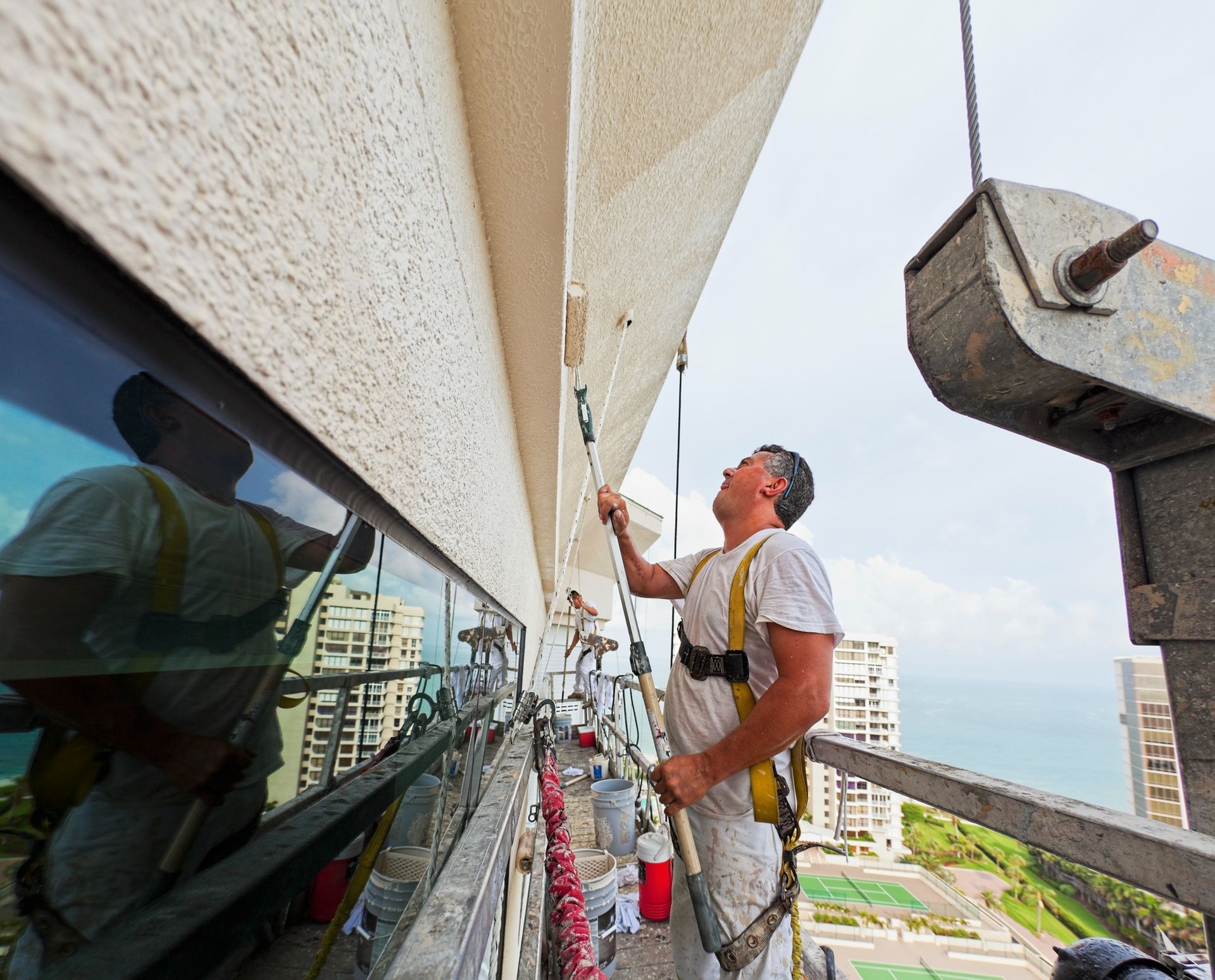 A man is painting the side of a building
