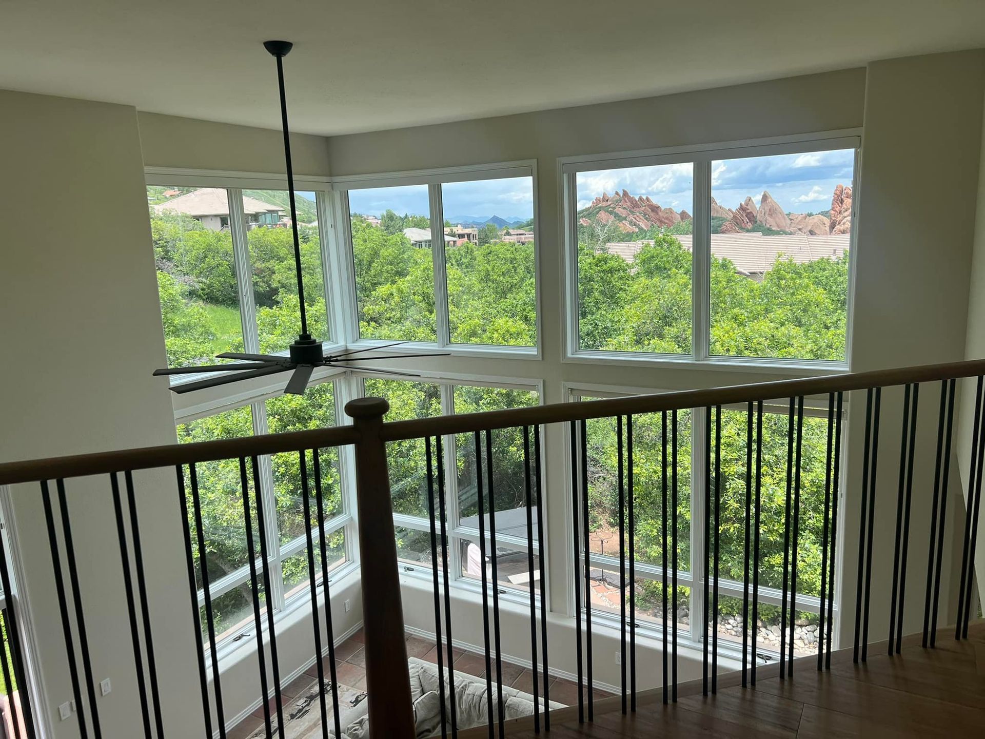 A room with a lot of windows and a ceiling fan.