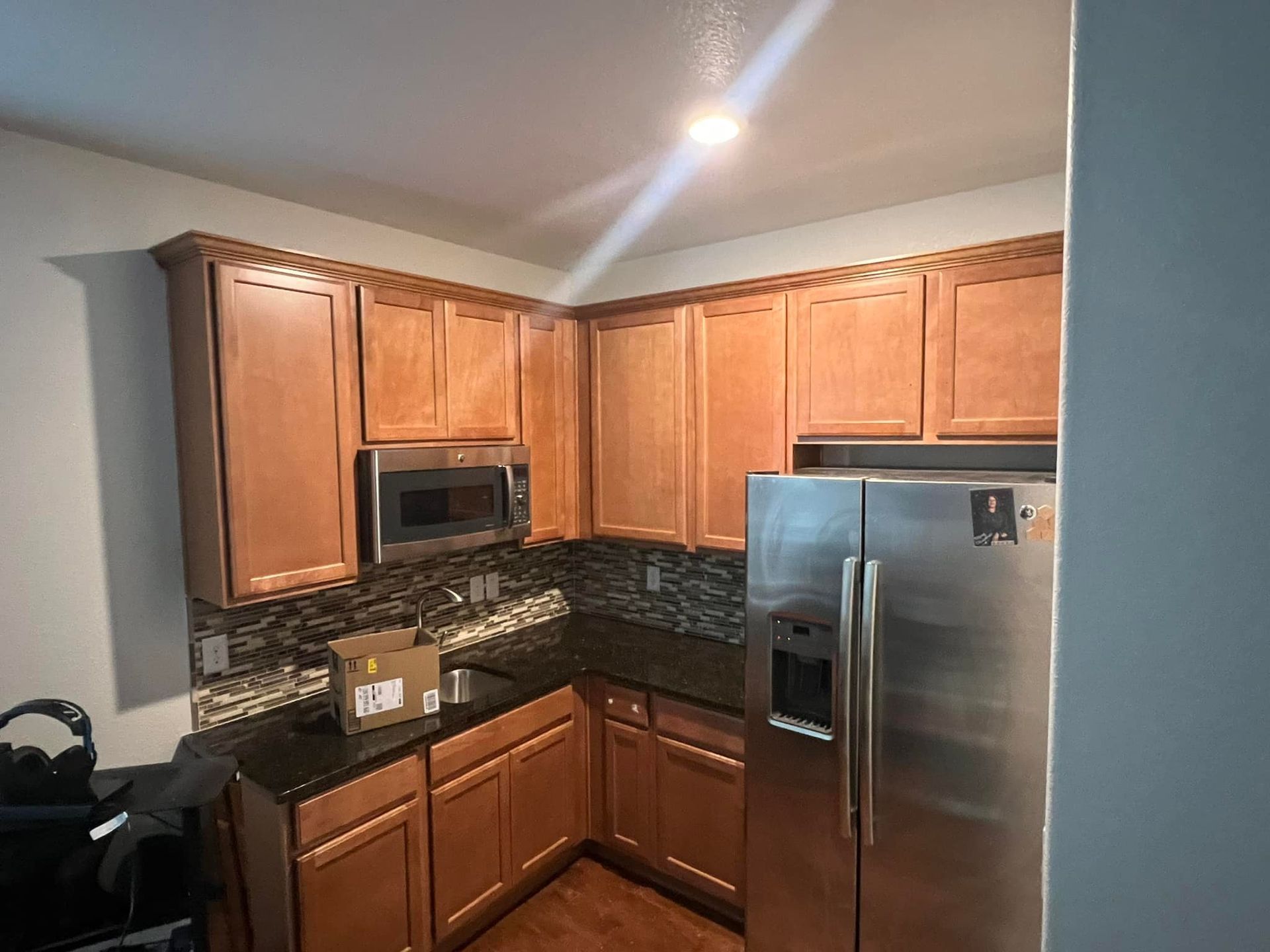 A kitchen with stainless steel appliances and wooden cabinets.