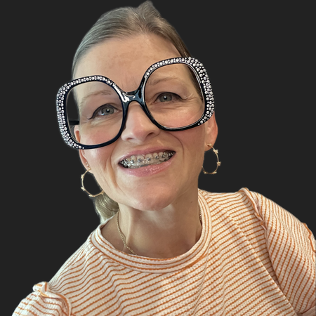 Smiling person wearing oversized black glasses and a striped shirt against a dark background