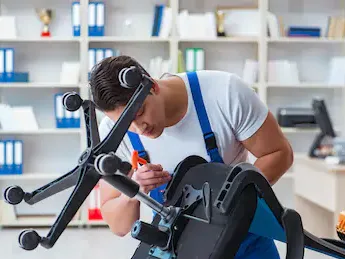 Homem consertando uma cadeira de escritório em um ambiente de escritório.