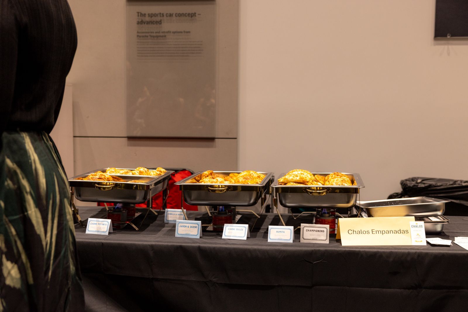 Buffet table with labeled trays of food and drinks in a banquet hall