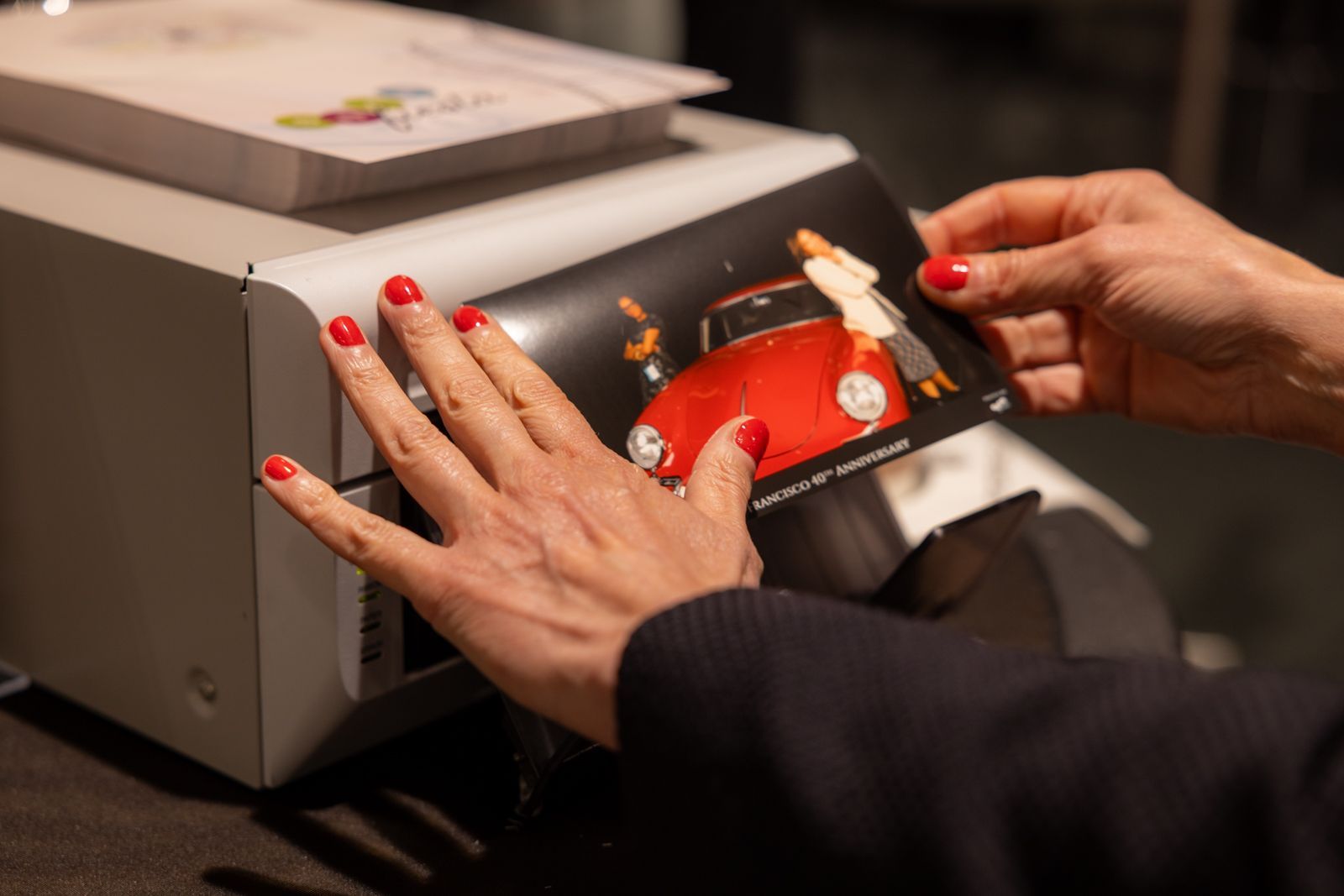 Hands with red nails inserting a card into a payment terminal at a checkout counter