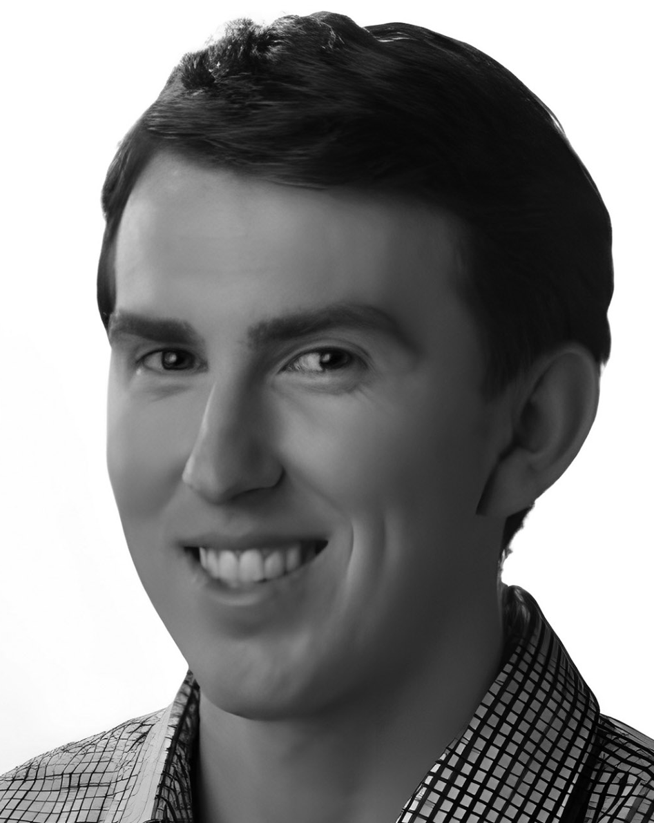 Black-and-white headshot of a smiling person in a checkered shirt on a plain background