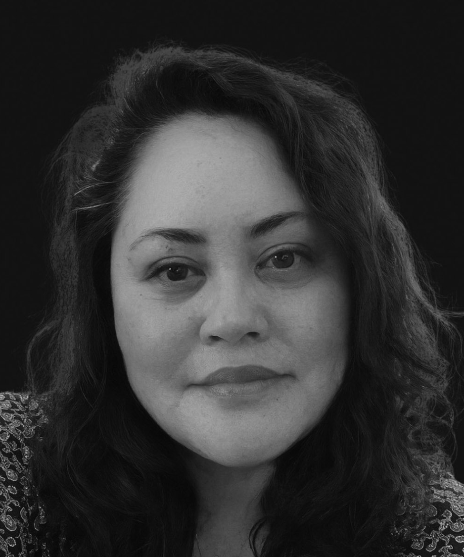 Black-and-white portrait of a person with wavy hair, facing forward with a neutral expression.