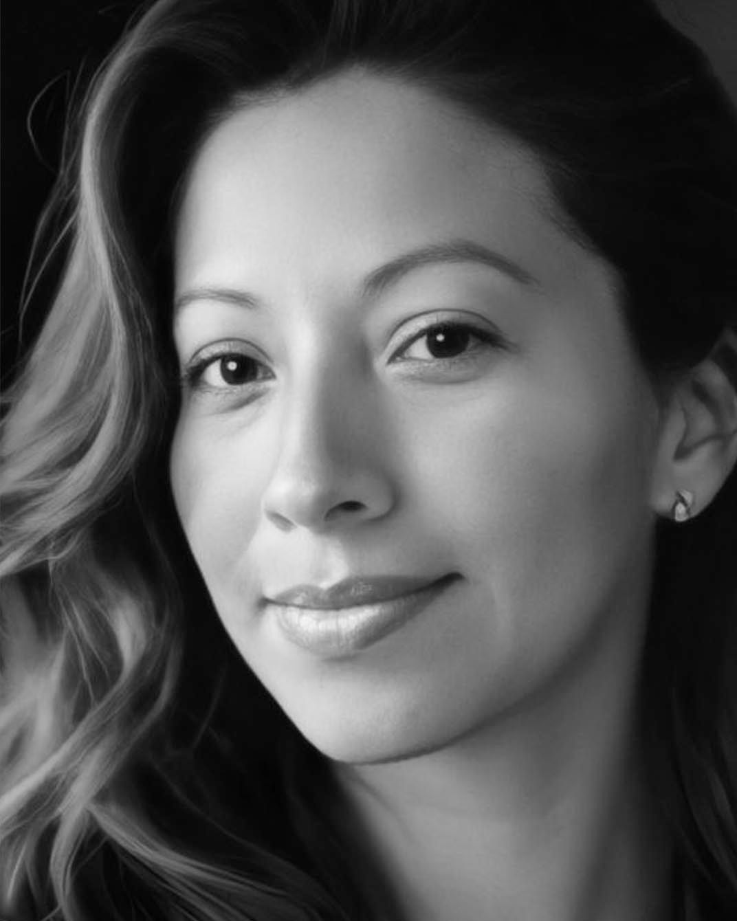 Black-and-white close-up portrait of a woman with wavy hair and a slight smile
