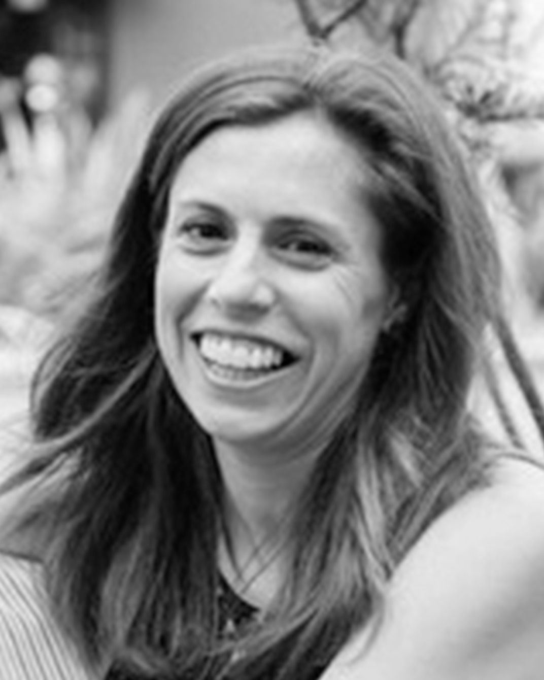 Smiling woman with long hair in a black-and-white portrait