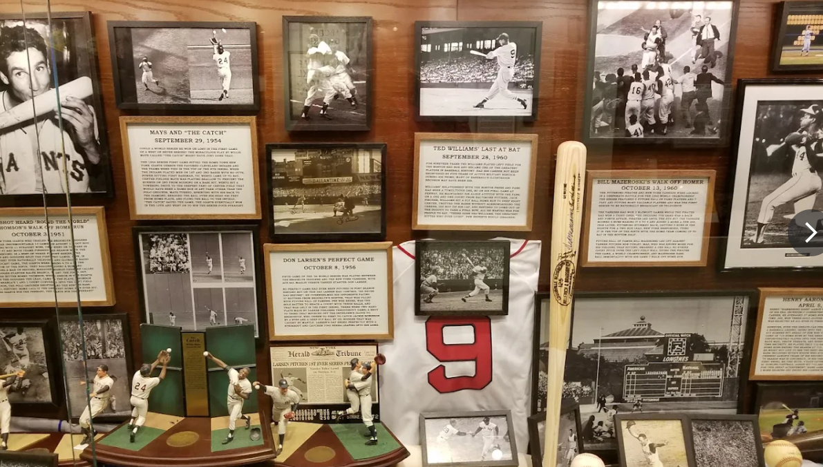 Vintage photo wall with framed black-and-white sports images, handwritten notes, and a red number 9