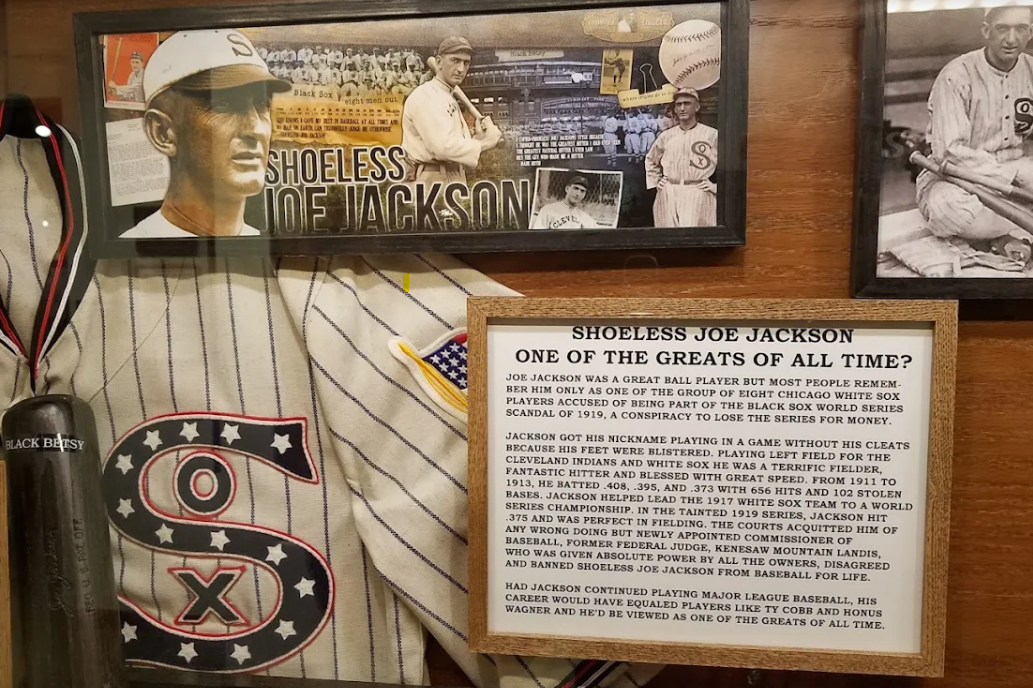 Baseball display with a Chicago White Sox jersey, historic player collage, and framed exhibit text.