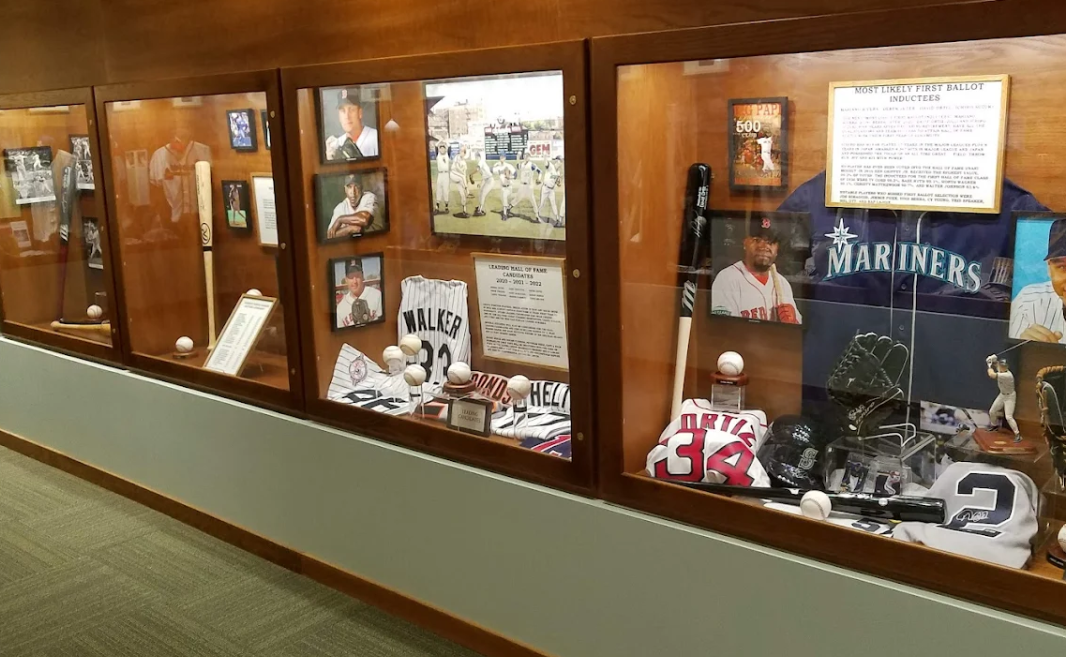 Glass display cases with assorted memorabilia and posters in a hallway.