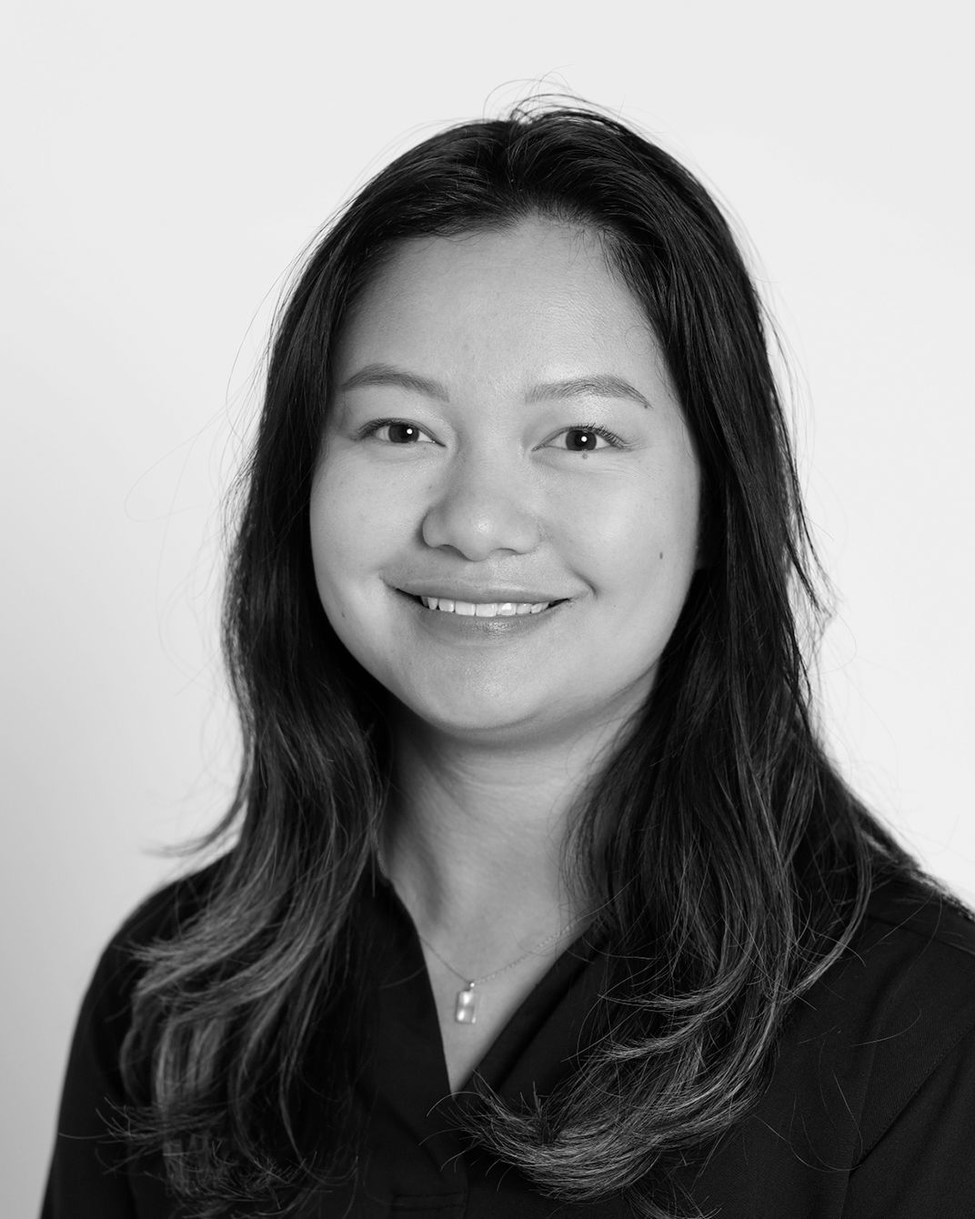 Smiling person in a black top against a light background