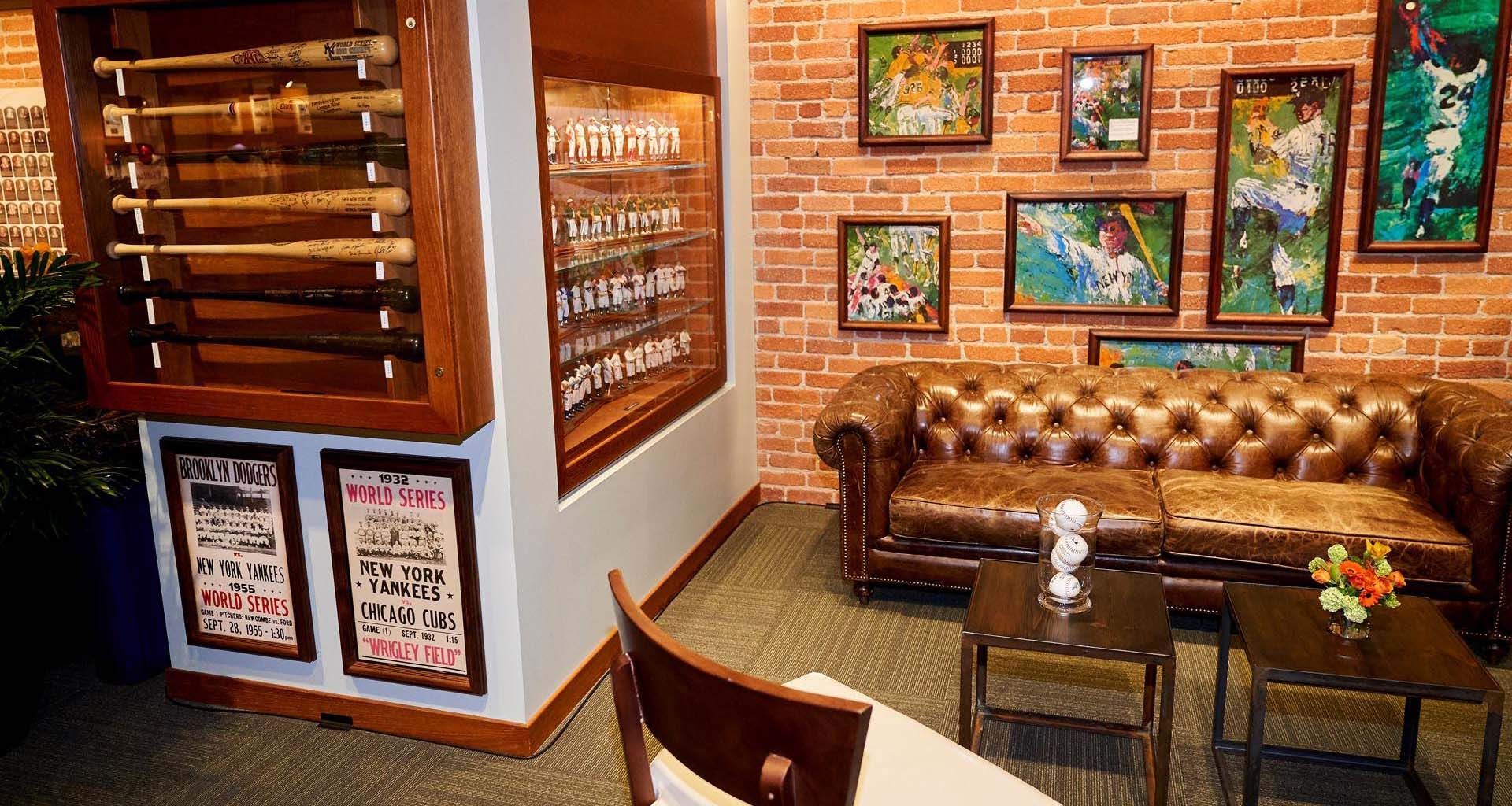 Cozy cafe corner with brown leather sofa, framed art, wooden decor, and a small table and chairs