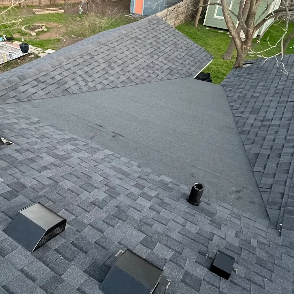 Roof with dark gray shingles and several roof vents, viewed from above.