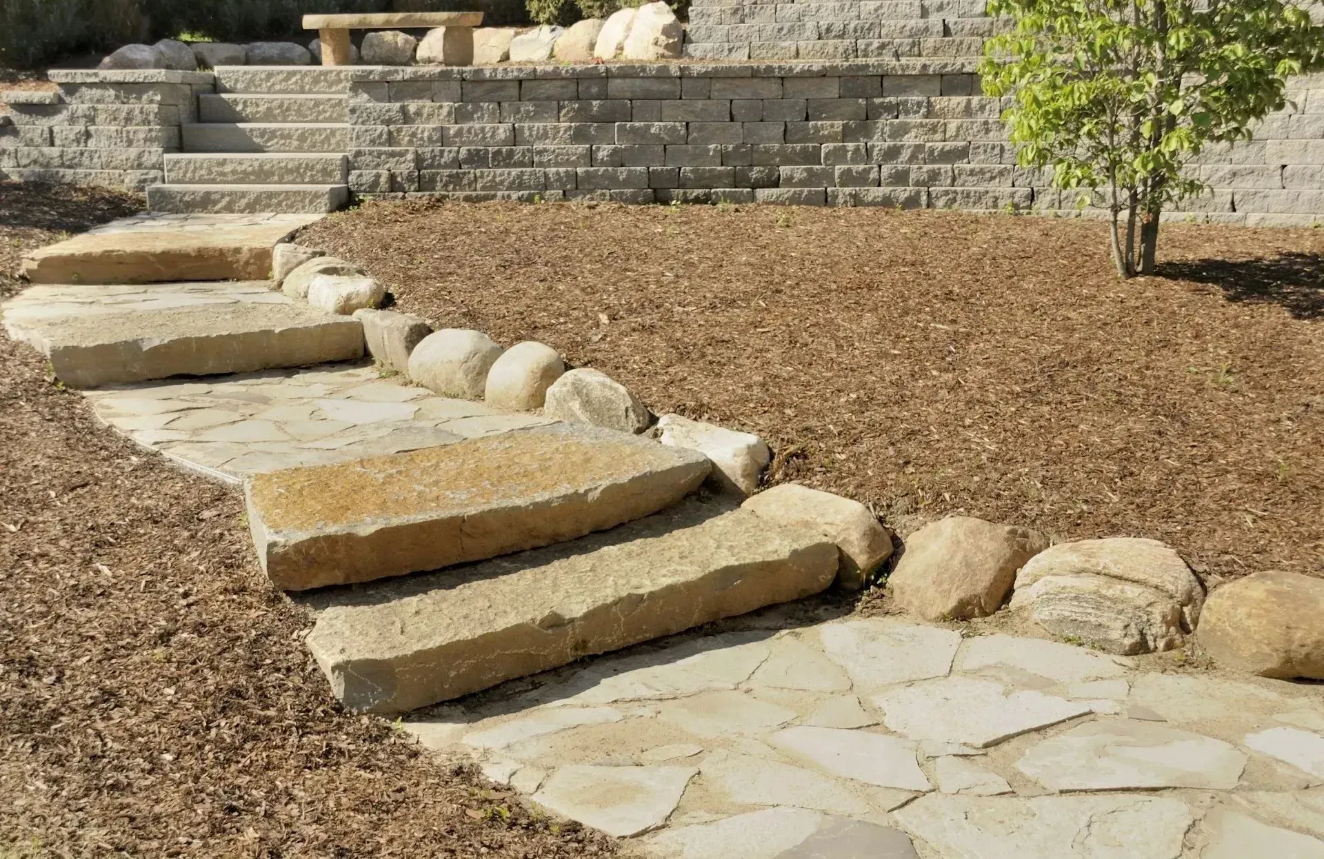 A brick wall is being built in a garden.