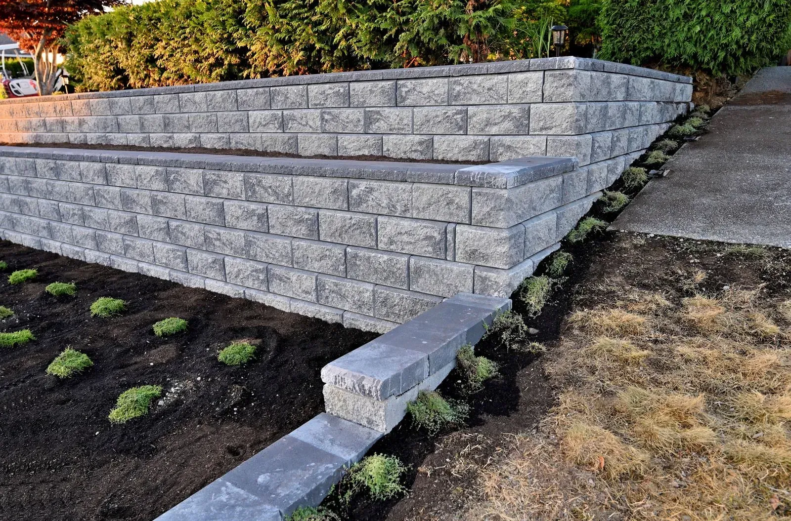 A brick wall is being built in a garden.