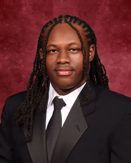 A man with dreadlocks is wearing a suit and tie