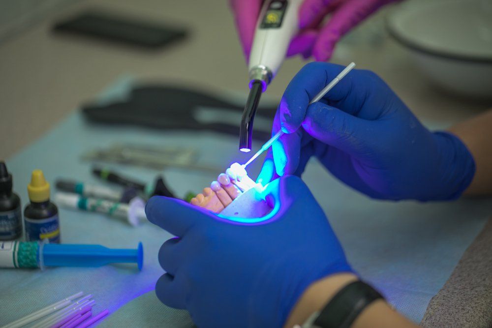 A Dentist is Working on a Patient 's Teeth With a Light — Ballina Denture Clinic Michael J Parker in Byron Bay, NSW