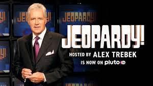 Alex Trebek stands in front of a Jeopardy! background in a promotional graphic for the show on Pluto TV.