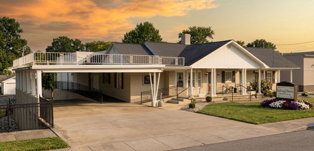Single-story suburban house with a carport, front porch, and driveway at sunset