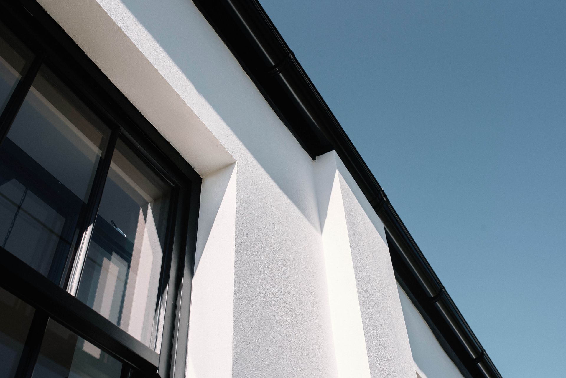 A staircase with a white railing and a skylight on the ceiling in a Large-Scale Retrofitting in East Sussex