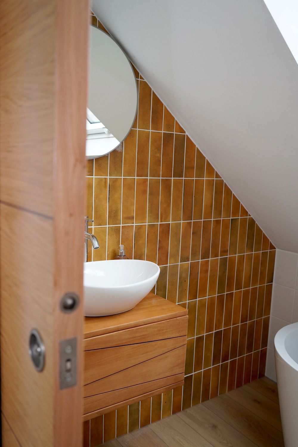 A bathroom with a sink , toilet and mirror  in a Large-Scale Retrofitting in East Sussex