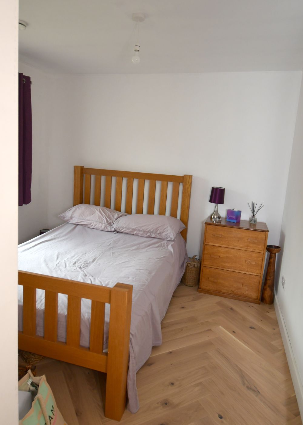 A bedroom with a wooden bed and a dresser  in a Construction Management in East Sussex