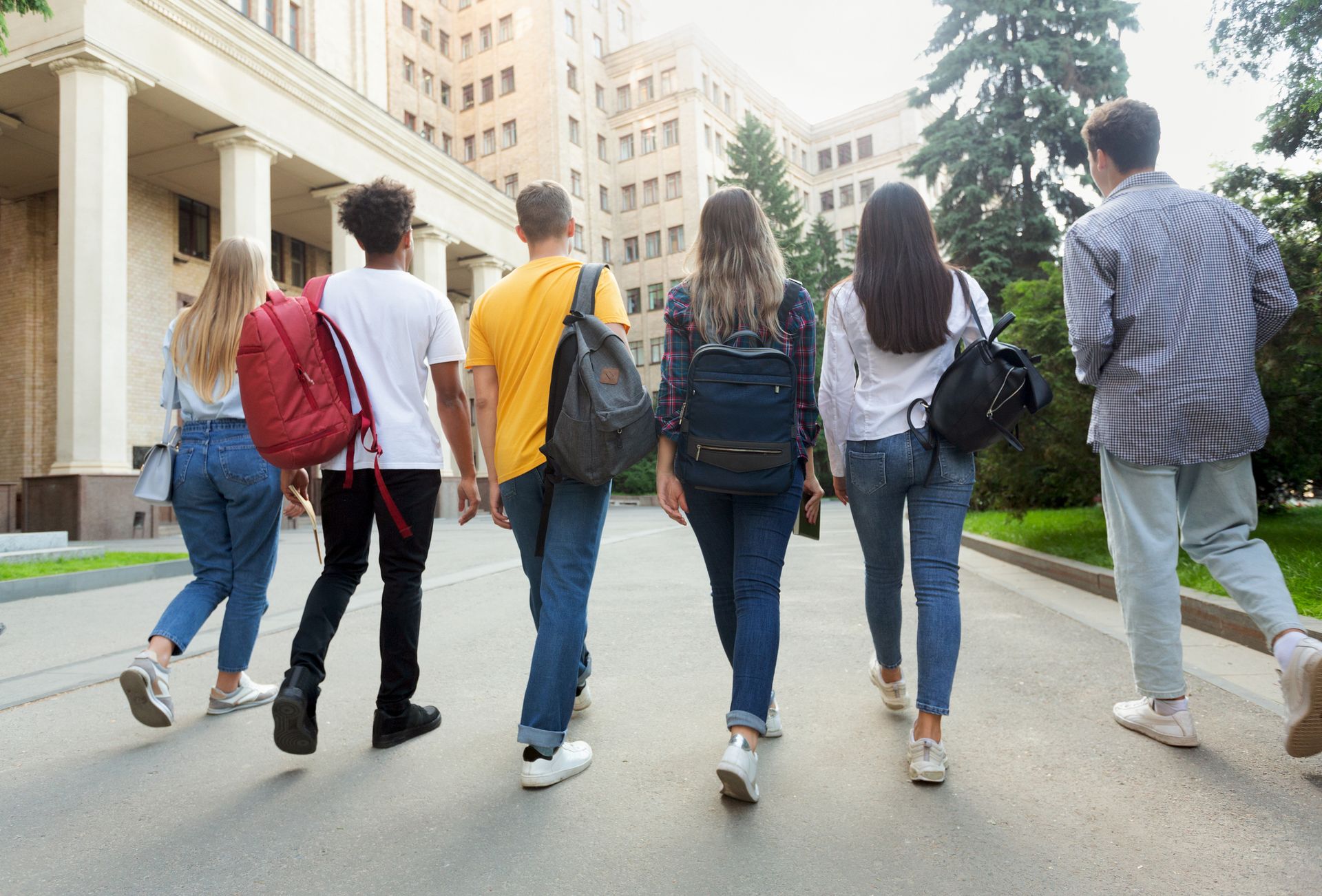 A group of young people are walking down a street. A group of young people are walking down a street.