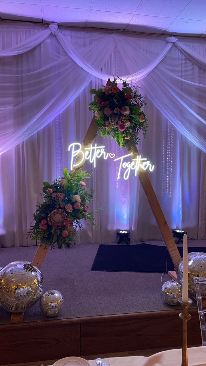 Wedding backdrop with floral arrangements, neon